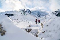 Pareja de senderismo durante el invierno en las rocas - foto de stock