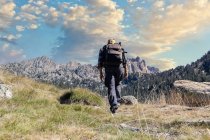 Male middle aged caucasian tourist walking by Spanish Pyrenees mountain during sunny day — Stock Photo