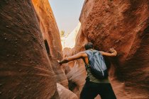 Young man exploring narrow slot canyons in Escalante, during summer — Stock Photo