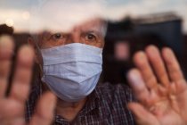 Літній білий чоловік у руці зробив захисну маску для обличчя, медсестра — стокове фото