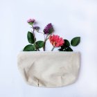 Schöne Blumen und Tasche auf Hintergrund, Nahaufnahme — Stockfoto