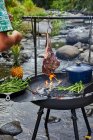 Шеф-повар готовит барбекю в кемпинге Кухня возле ручья — стоковое фото