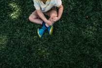 Jovem sentado na grama em um dia ensolarado — Fotografia de Stock