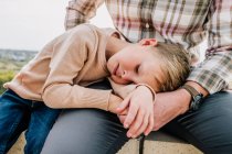 Young boy cuddling father outside — Stock Photo