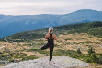 Жінка займає пози йоги в природі гірський спокій — стокове фото