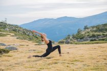 Woman doing yoga poses in nature mountain peace — Stock Photo