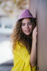 Glückliche junge Frau lehnt an Wand — Stockfoto