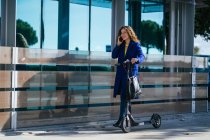 Donna felice con scooter che parla su smartphone — Foto stock