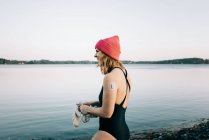 Mulher entrando na água calma pronta para nadar em água fria na Suécia — Fotografia de Stock