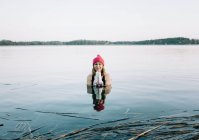 Donna in cappello rosso nuotare nel lago — Foto stock