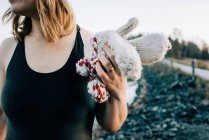 Frau hält Handschuhe für kaltes Wasser bereit, das im Meer schwimmt — Stockfoto