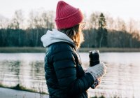 Frau hält nach Kaltwasserschwimmen in Schweden Heißgetränk in der Hand — Stockfoto