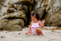 Lindo asiático bebé chica tener divertido en la playa - foto de stock