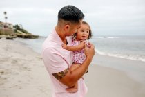 Молодий азіатський жир з дитиною розважається на пляжі — стокове фото