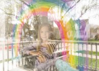 За окном девушка рисует радугу на окне — стоковое фото