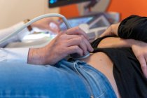 Close-up de médico examinando barriga de mulher grávida com ultra-som — Fotografia de Stock