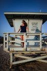 Jovem mulher caucasiana atraente olhando para o mar da torre salva-vidas na praia de Malibu, Califórnia — Fotografia de Stock