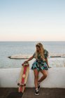 Молода жінка скейтбордист на пляжі — стокове фото