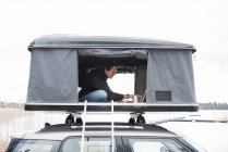 Mann arbeitet im Zelt mit Blick auf soziale Distanz zum Büro — Stockfoto