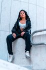 Young girl sitting with braids and tattoos urban photo in the city — Stock Photo