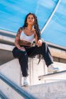 Young black girl with tattoos, trap dancer sitting in the city — Stock Photo