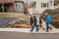 Una passeggiata in famiglia con il cane attraverso il quartiere suburbano — Foto stock