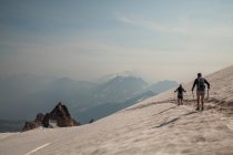 Two climbers descends a snowfield after summiting Glacier Peak in the Glacier Peak Wilderness in Washington. (released: Sam Thompson and Brock Gavery) — Stock Photo