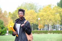Afrikanische Studentin mit Mundschutz draußen auf dem Campus. Neue Normalität im College. — Stockfoto