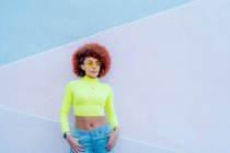 Portrait of gorgeous woman with afro hair over pink wall — Stock Photo