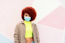 Portrait of beautiful woman with afro hair wearing mask — Stock Photo