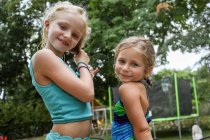Portrait of two girls standing together in backyard in summertime — Stock Photo