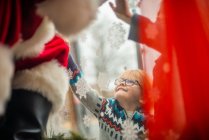 Niño alcanza hasta para conectarse a Santa durante covid - foto de stock