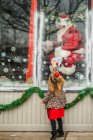 Toddler reaches for santa through window — Stock Photo