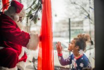 Young tween girls connects with Santa in window — Stock Photo