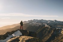 Young man admiring rugged snowcapped mountain landscape at sunset, Gredos, Spain — Stock Photo