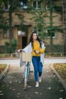 Young woman with her bicycle on the street. — Stock Photo