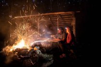 Faíscas surgem de uma fogueira enquanto dois caminhantes assistem, Appalachian Trail. — Fotografia de Stock