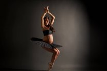 Jovem bailarina grávida realizando pose de balé clássico — Fotografia de Stock