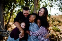 Fünfköpfige Familie umarmt und lacht im Park in Chula Vista — Stockfoto