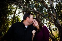 Marido y esposa posando bajo el árbol en el parque en Chula Vista - foto de stock
