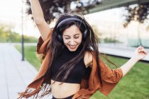 Молода жінка в голові телефону танцює на вулиці — стокове фото