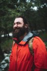 Homme barbu dans la nature pendant une journée enneigée souriant joyeusement — Photo de stock