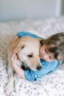 Мягкий момент между заботливой маленькой девочкой и собакой на кровати — стоковое фото