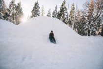 Young Boy Sledding Quickly Down a Hill — Stock Photo
