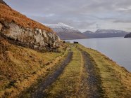 Estrada de cascalho ao longo da baía nas Ilhas Faroé — Fotografia de Stock