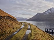 Strada sterrata lungo la baia nelle Isole Faroe — Foto stock