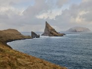 Formations rocheuses Drangarnir et Tindhlmur au loin dans les îles Féroé — Photo de stock