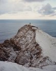 Due persone in piedi sul bordo della scogliera innevata nelle Isole Faroe — Foto stock