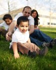 Famiglia seduta nell'erba nel parco — Foto stock
