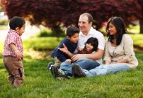 Familie sitzt im Gras im Park — Stockfoto